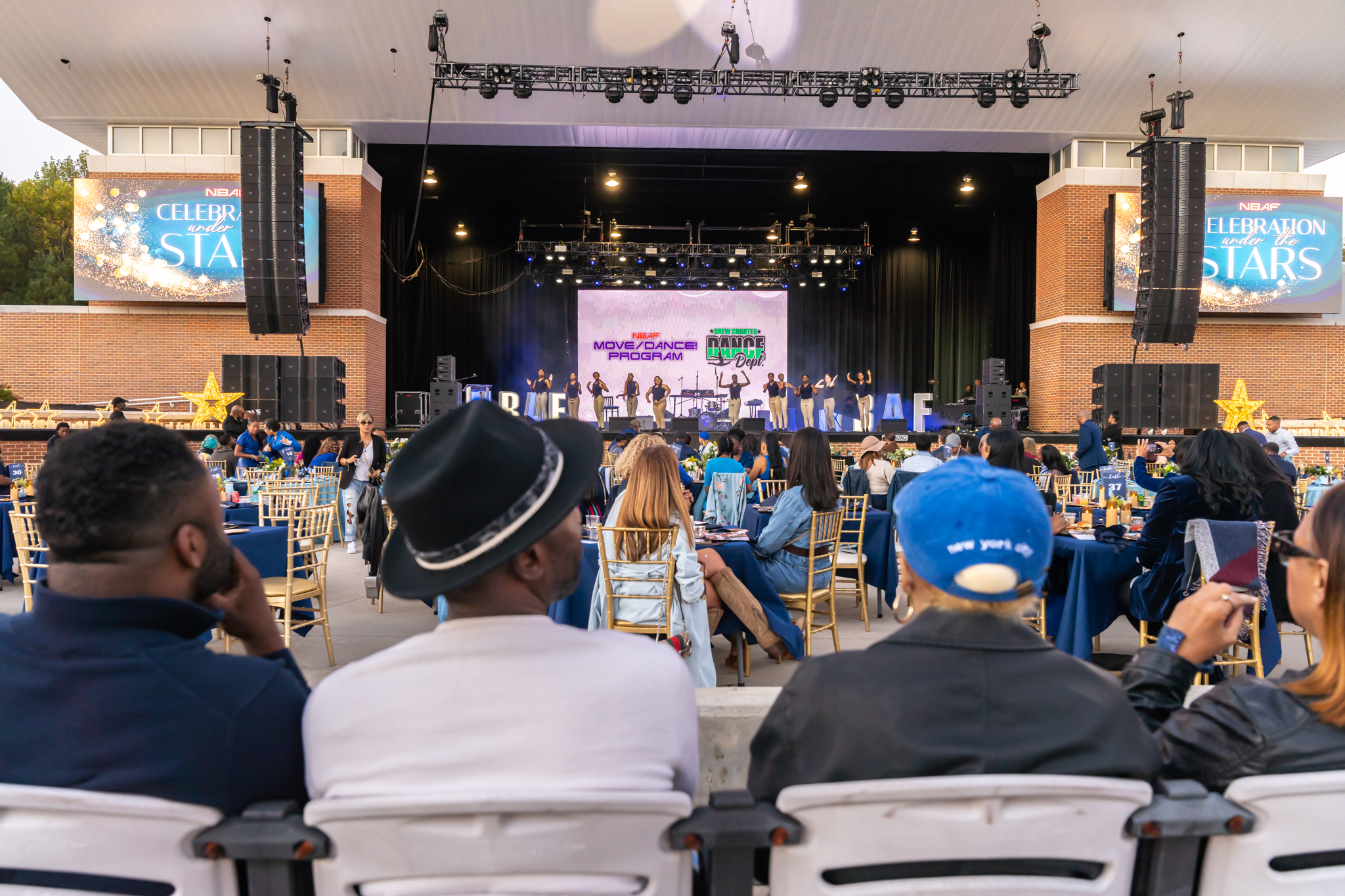 Dancers on stage with projector screen in background