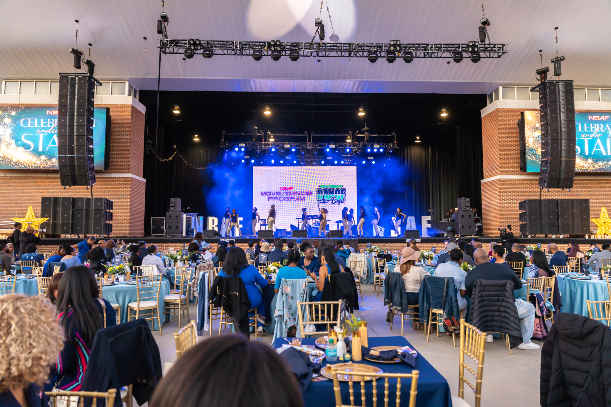 Dancers on stage with projector screen in background