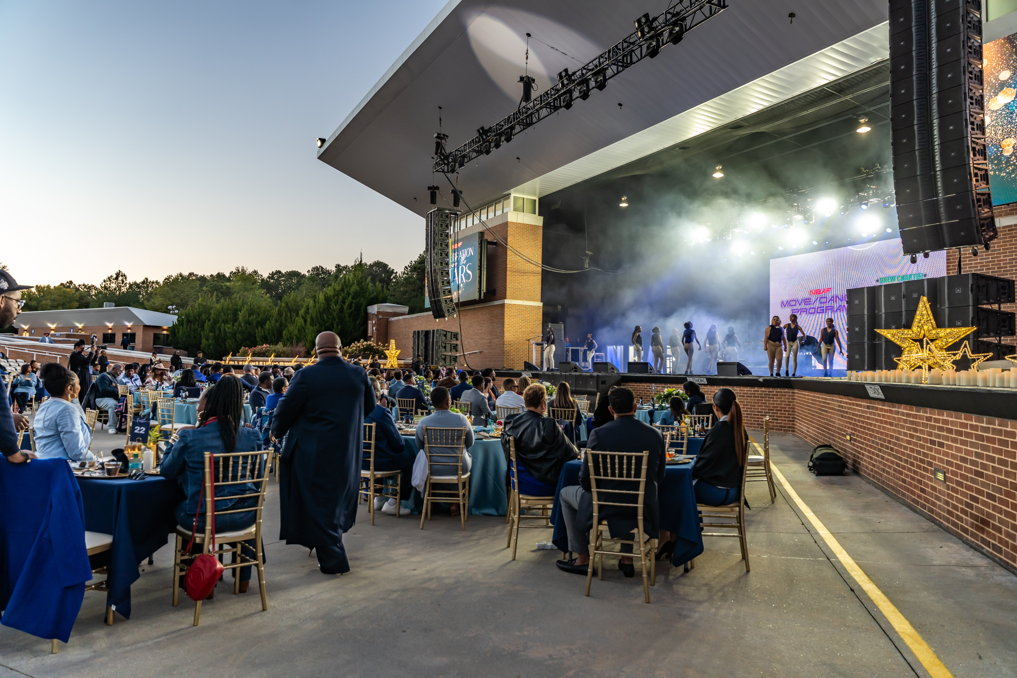 Dancers on stage with projector screen in background