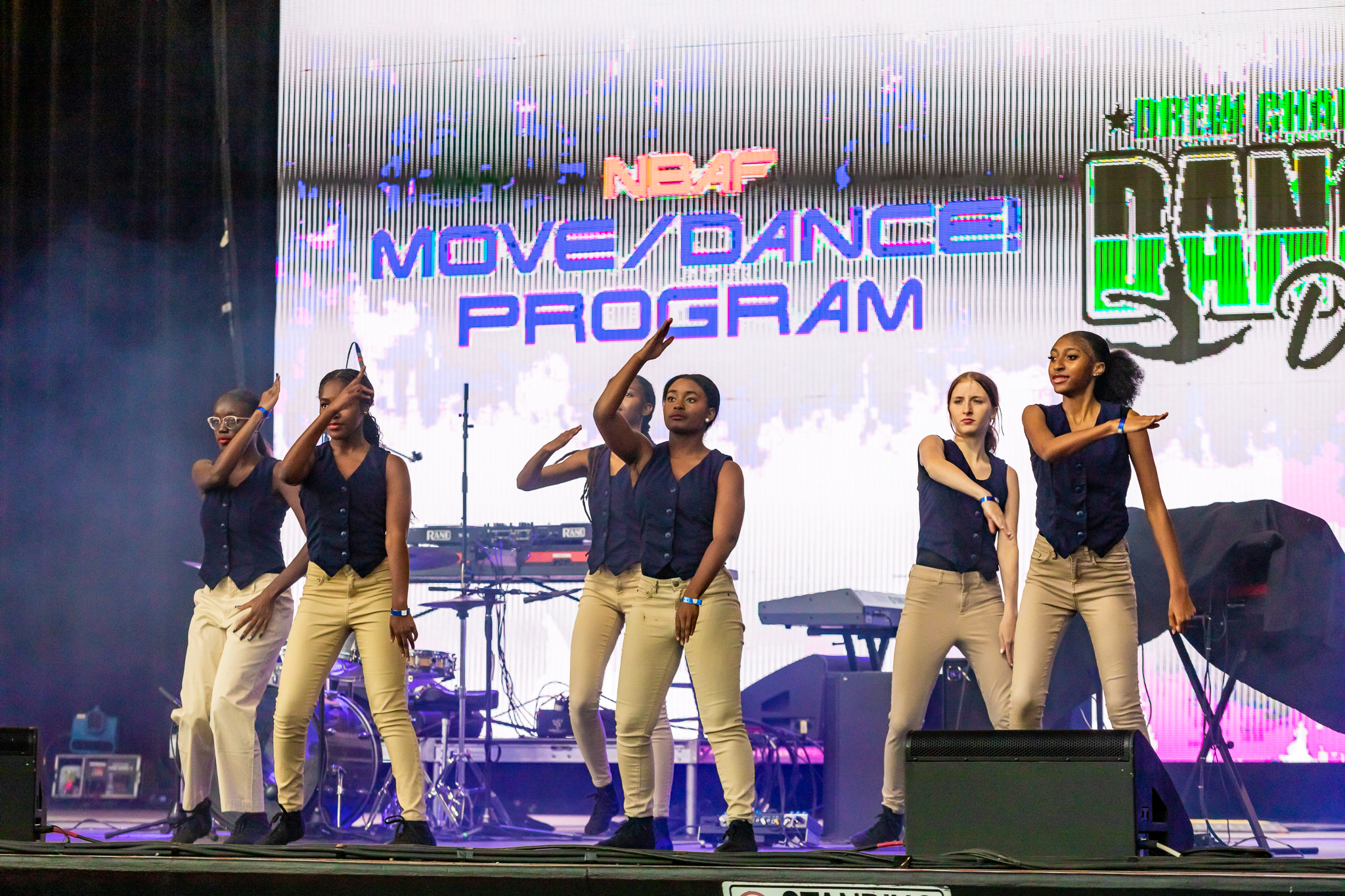 Dancers on stage with projector screen in background
